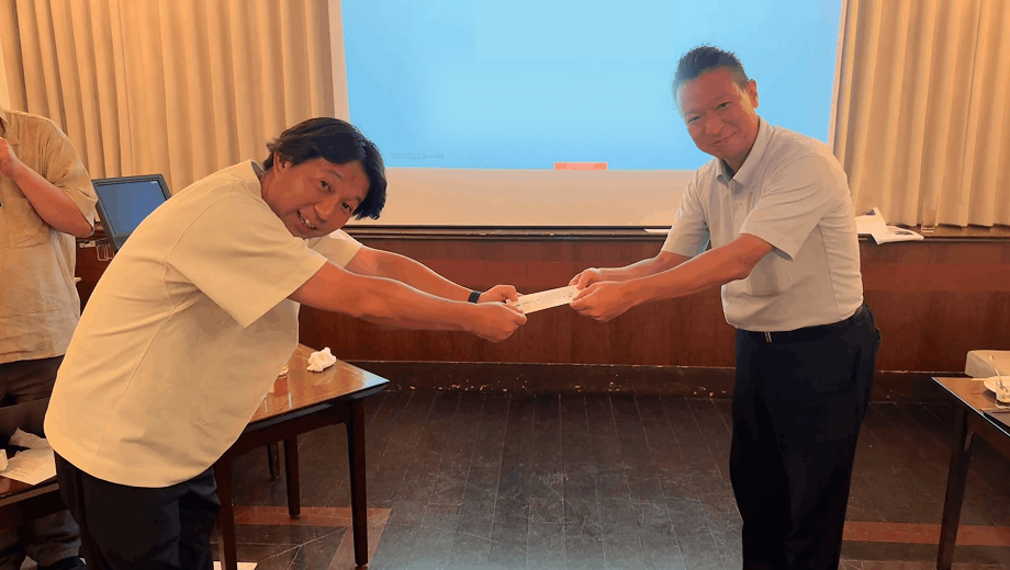 弊社社員、杉田さんがAI生成コンテストの「かっこよさ賞」を授与している様子。